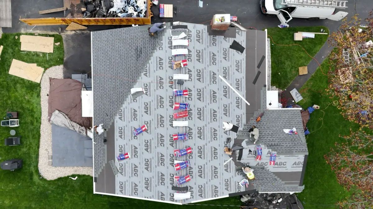 Aerial view of a house roof with colorful decorations, surrounded by lawn and driveways.