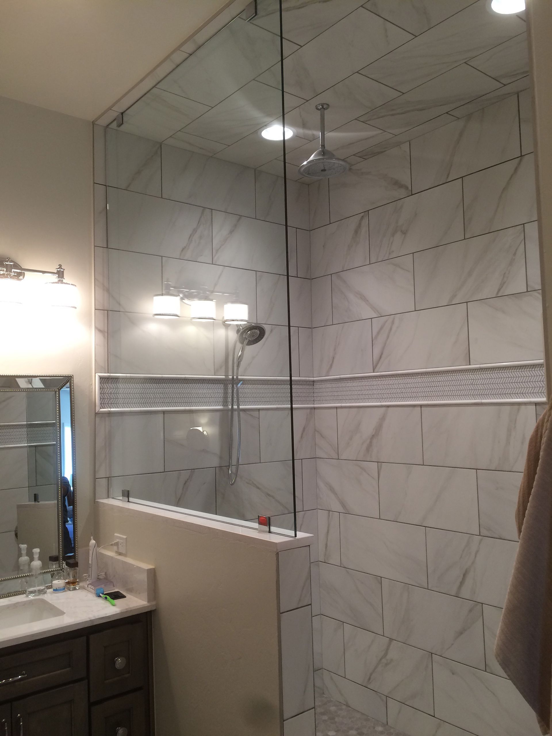 A bathroom with a walk in shower and a sink