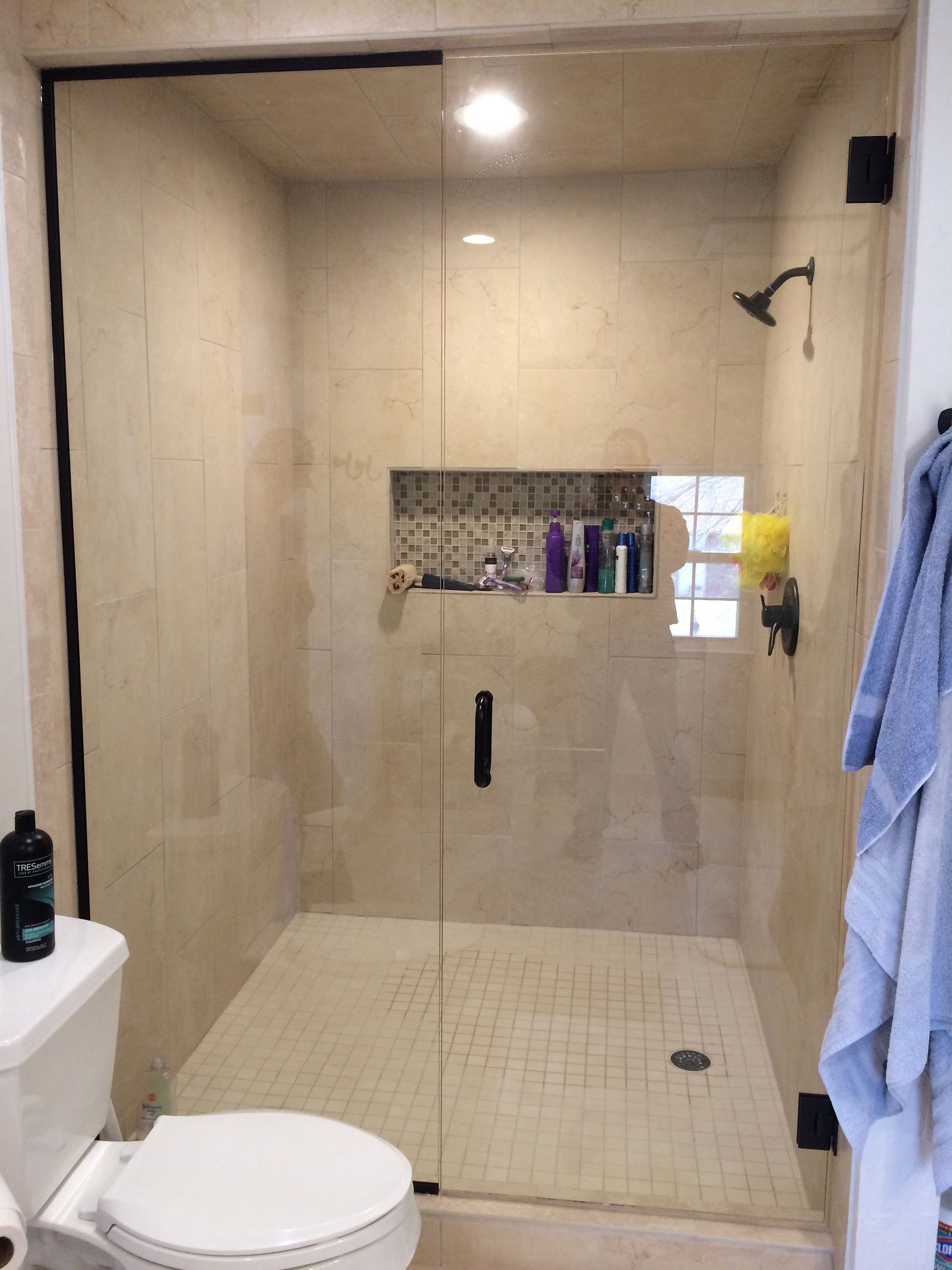 A bathroom with a toilet and a shower with a glass door