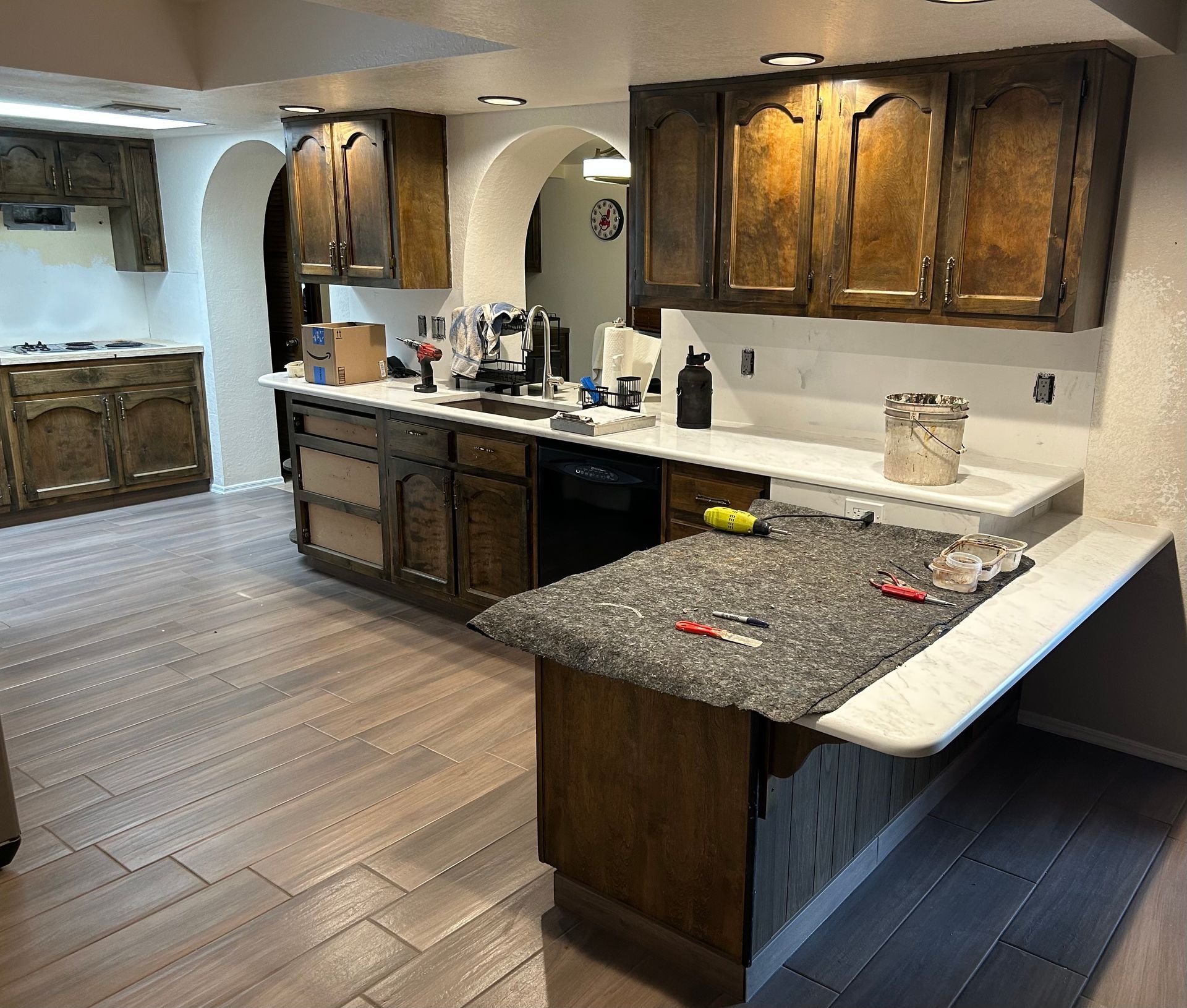Spacious kitchen with dark wood cabinets, granite countertops, and light tile flooring.