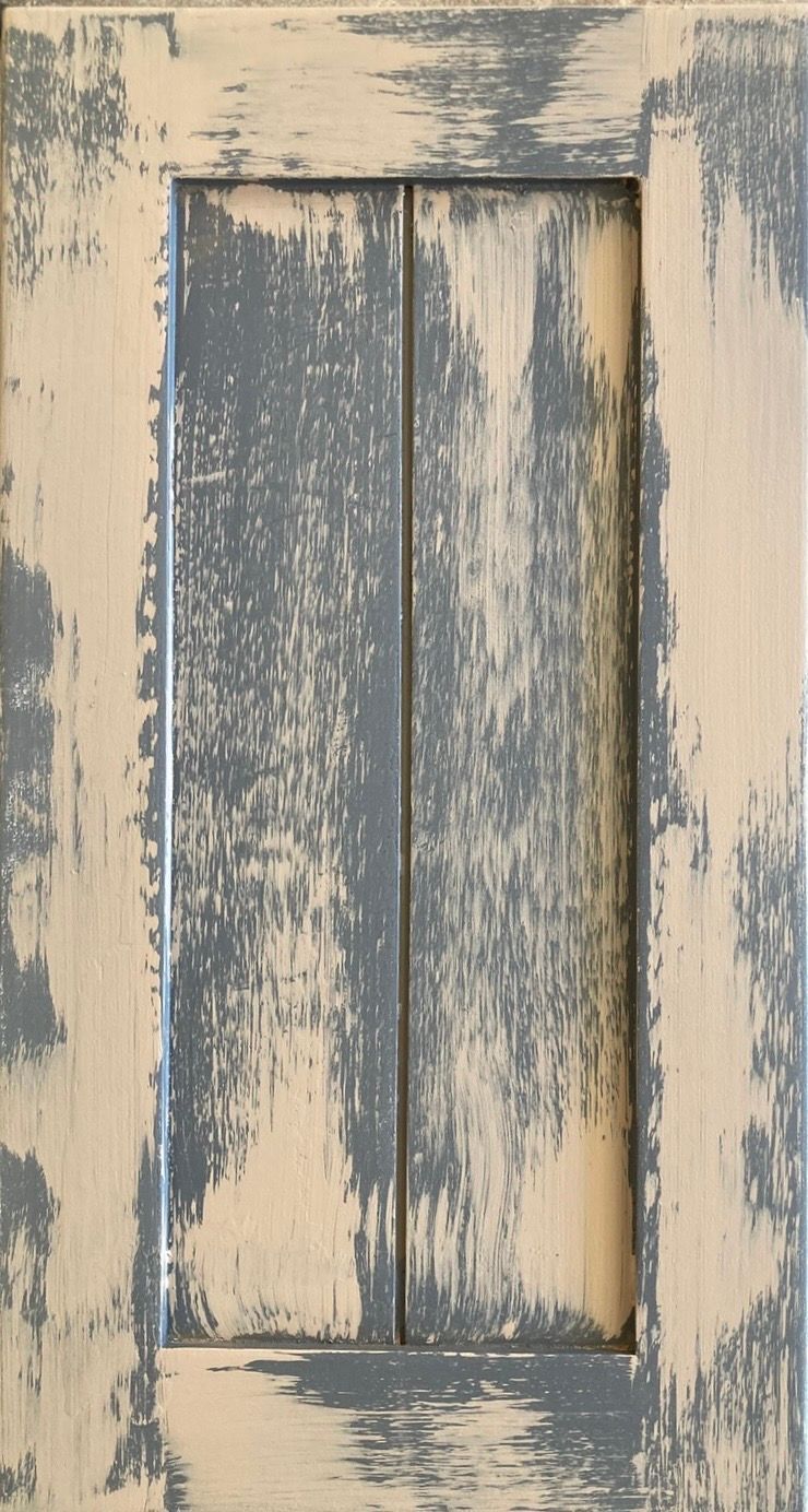 Distressed blue-gray and beige wooden panel door with peeling paint and a narrow inset center panel.