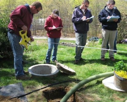 a group of people are measuring a hole in the ground