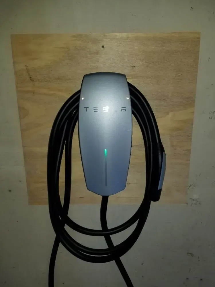 a tesla charger is attached to a wooden board