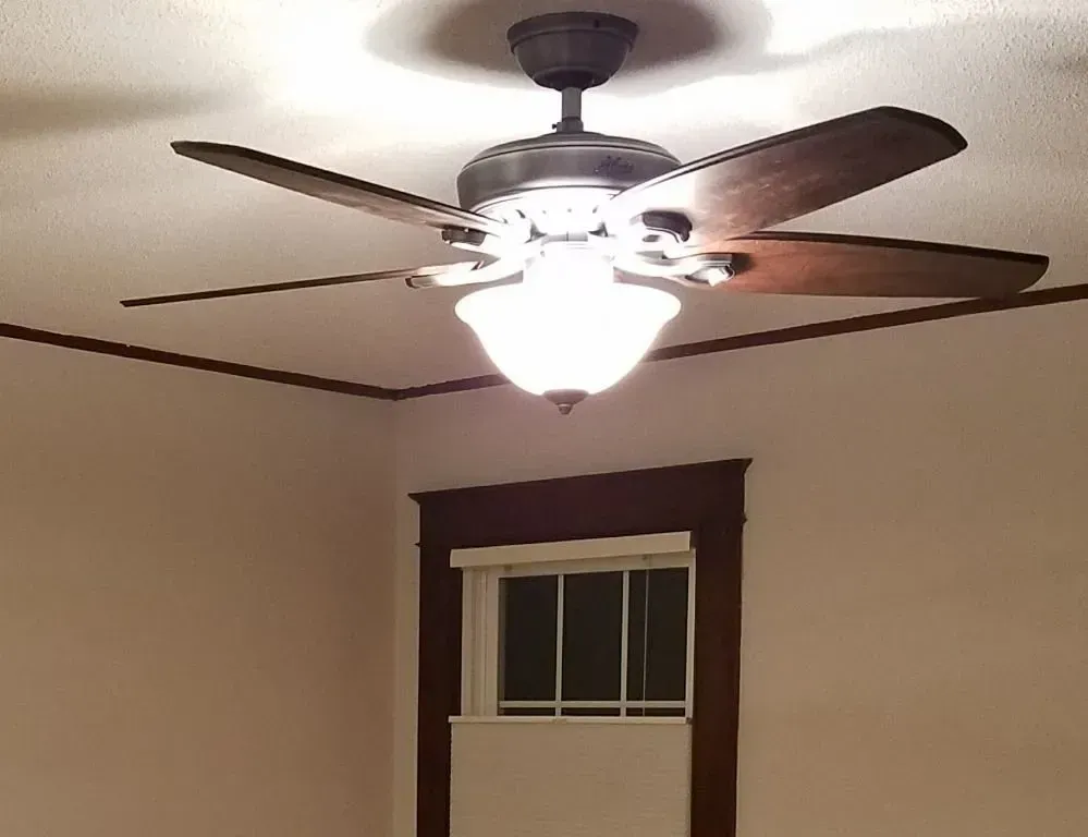 a bedroom with a ceiling fan and a window