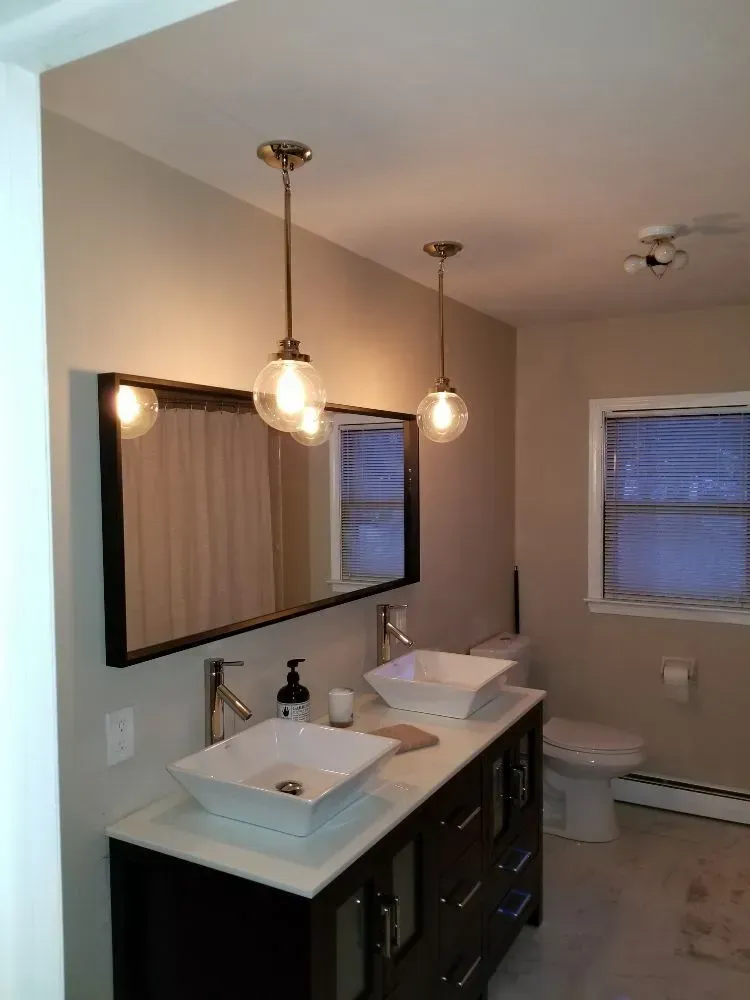 a bathroom with two sinks, a toilet, and a mirror