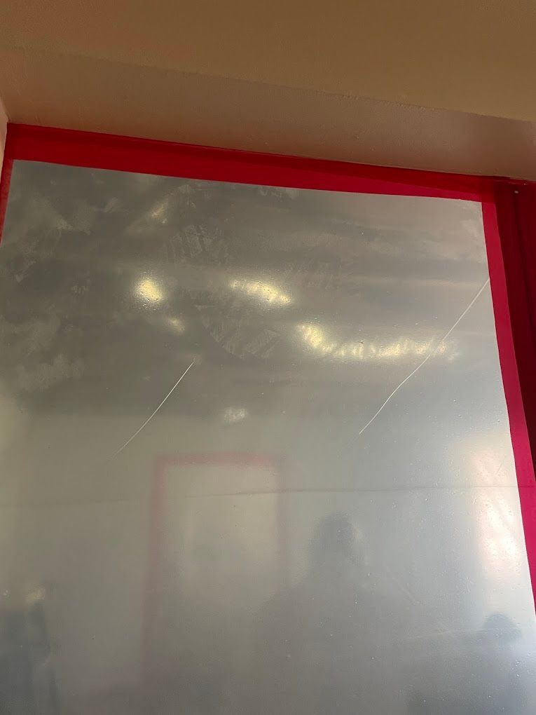 Room with a tarped-up wall and red tape