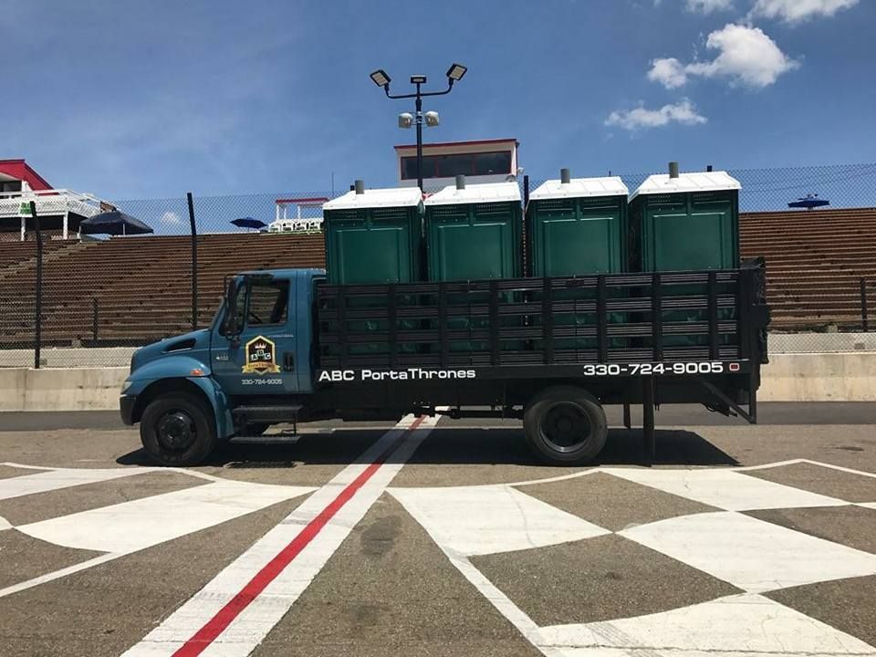 A truck is parked in a parking lot with portable toilets in the back.