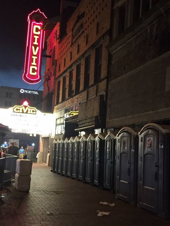A row of portable toilets in front of a civic theater