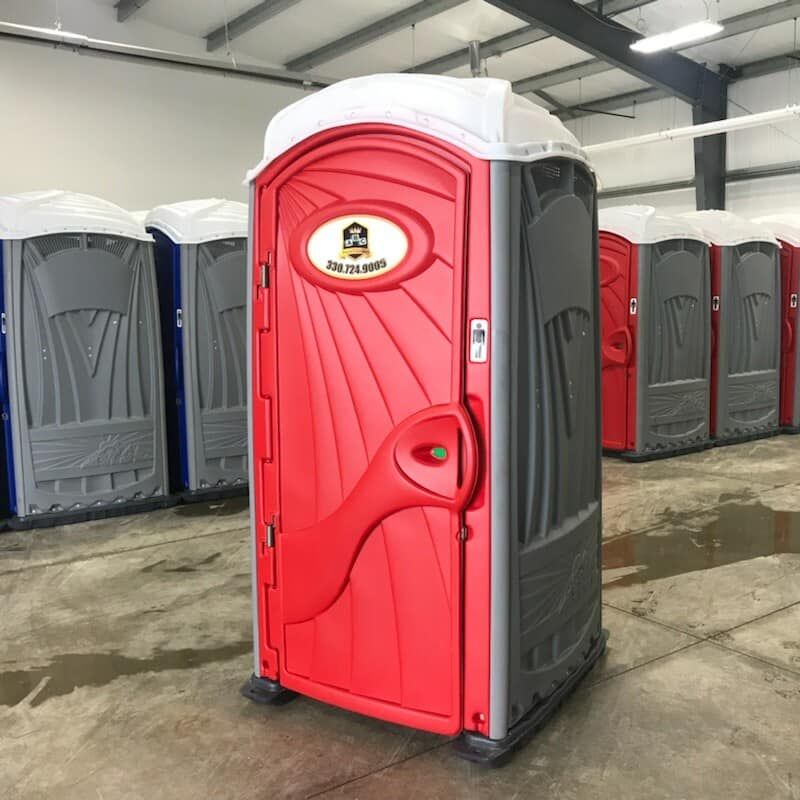 A row of portable toilets are lined up in a warehouse