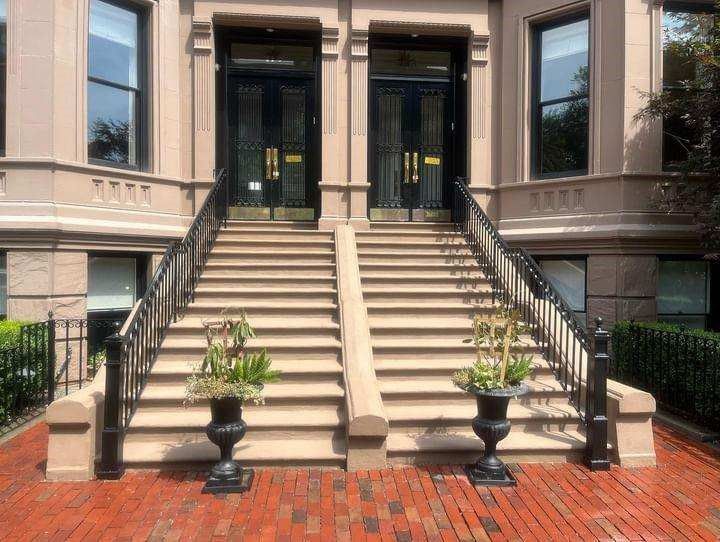A building with stairs and potted plants in front of it