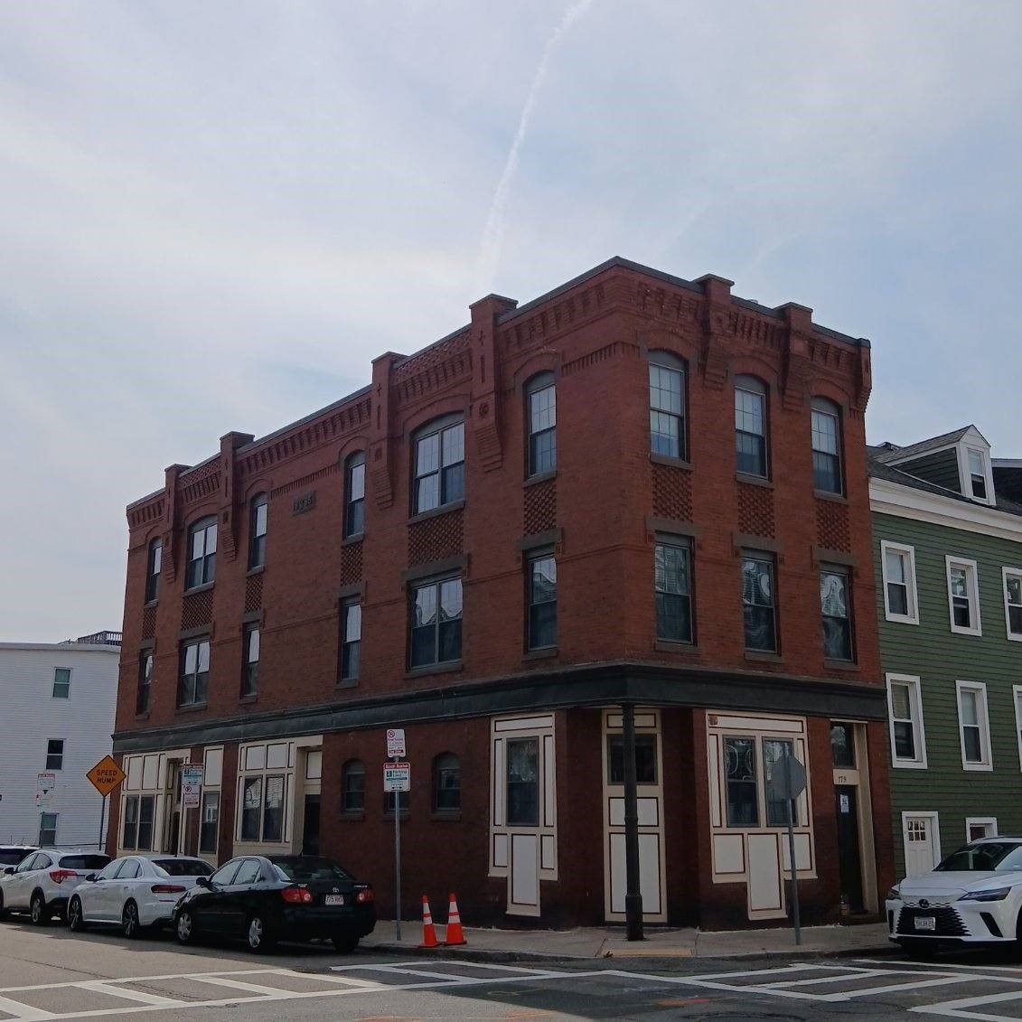 A brick building with cars parked in front of it