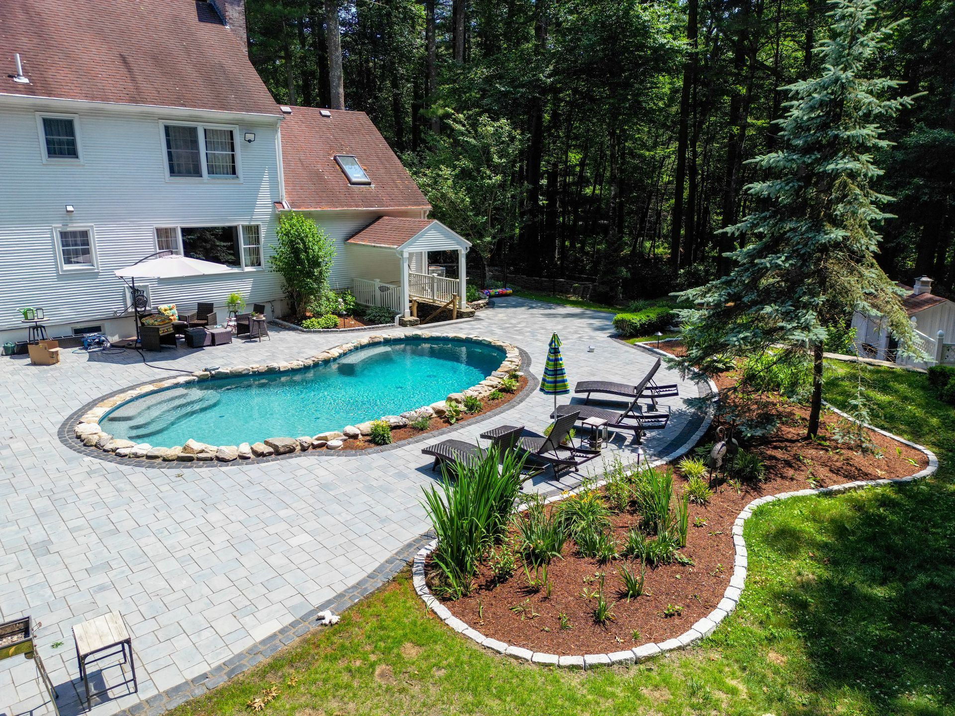 There is a large swimming pool in the backyard of a house.