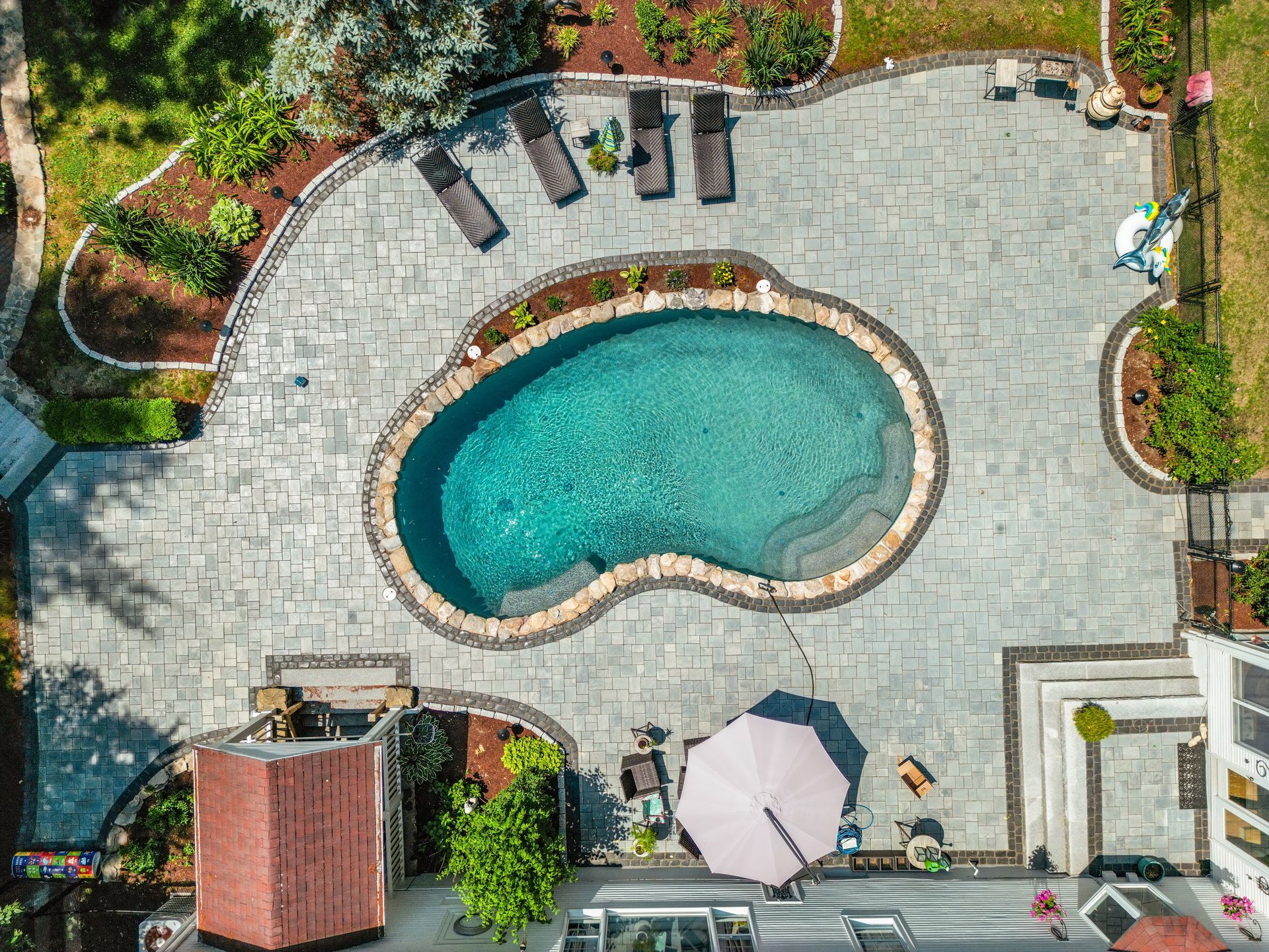 An aerial view of a large swimming pool in a backyard.