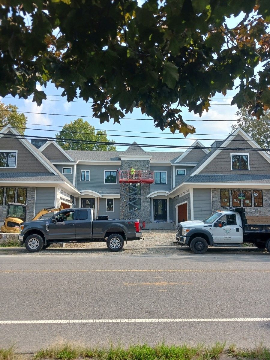 two trucks are parked in front of a house under construction