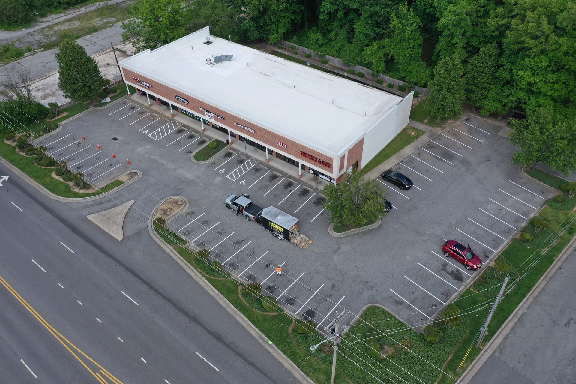An aerial view of a building with a parking lot in front of it.