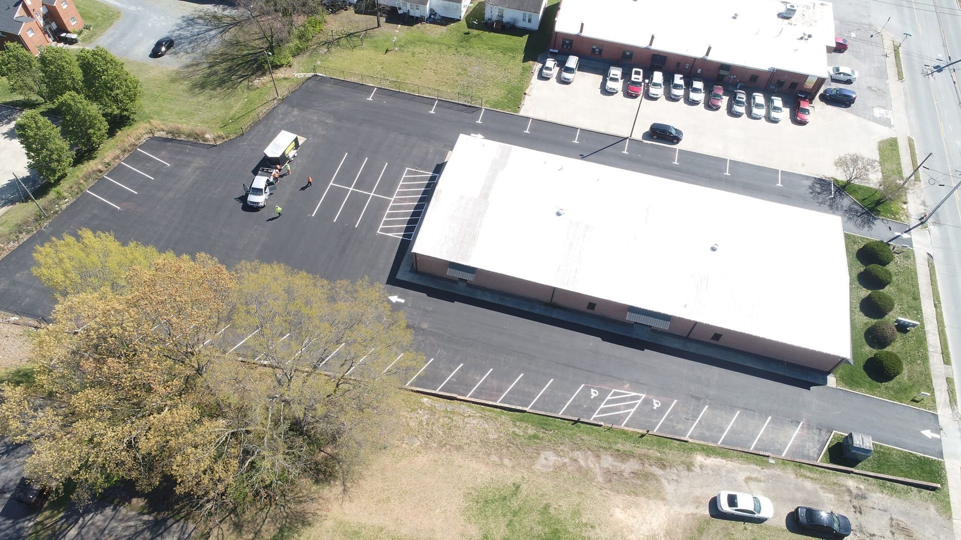 An aerial view of a parking lot with a building in the background