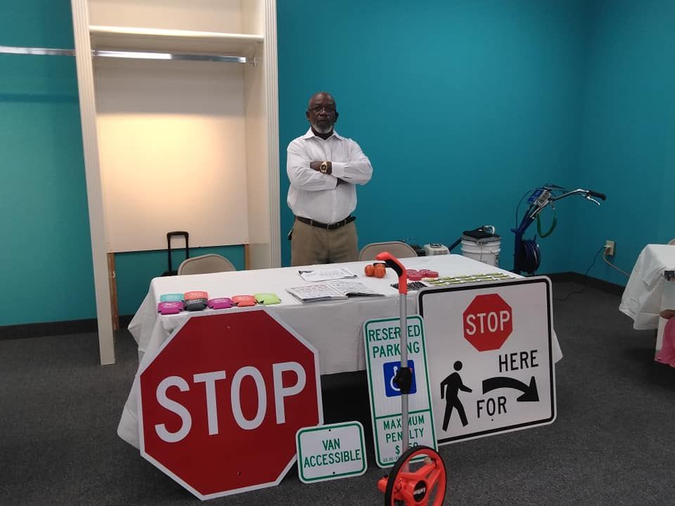 A man stands in front of a table with a stop sign on it