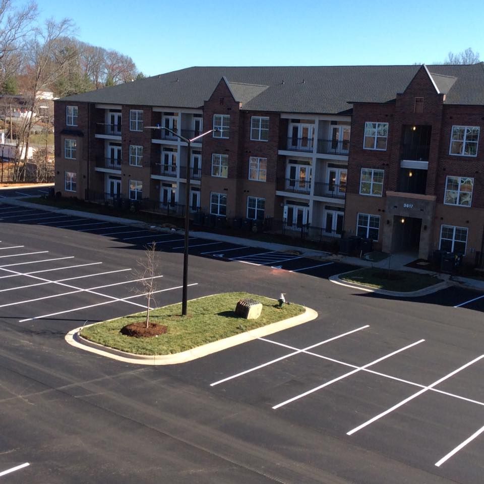 A large apartment building with a parking lot in front of it