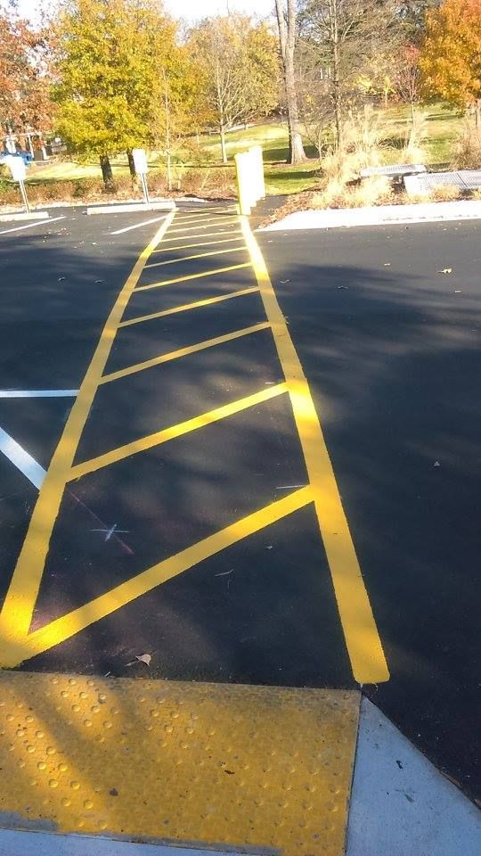 A parking lot with yellow lines and a ramp.