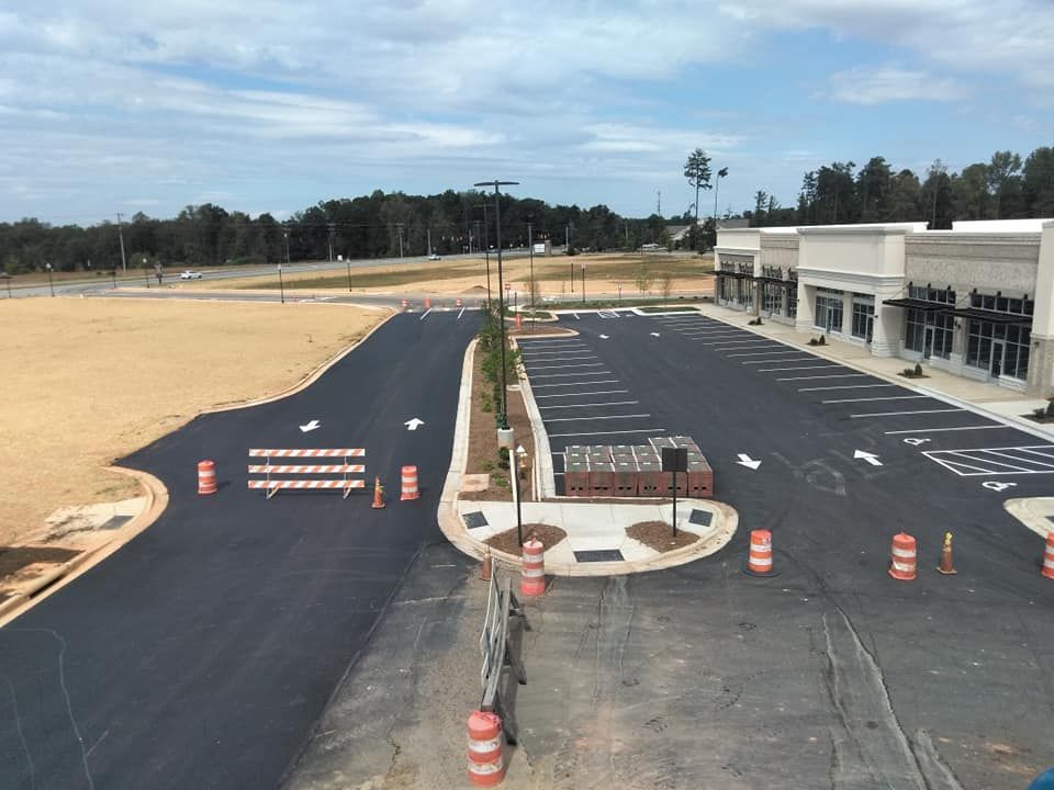 An aerial view of a parking lot with a building in the background.