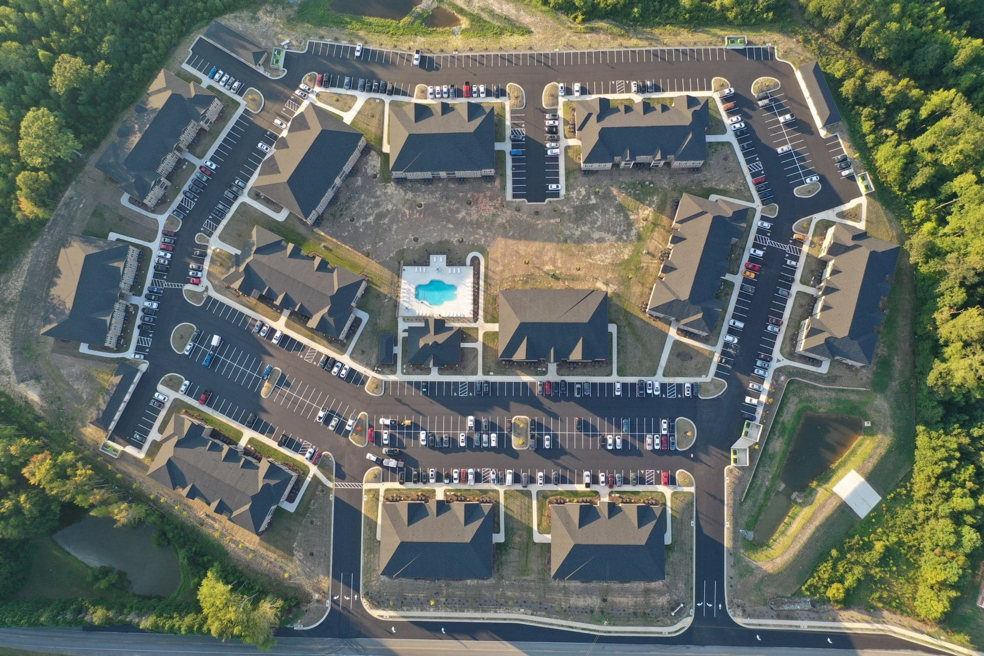 An aerial view of a building with a pool in the middle