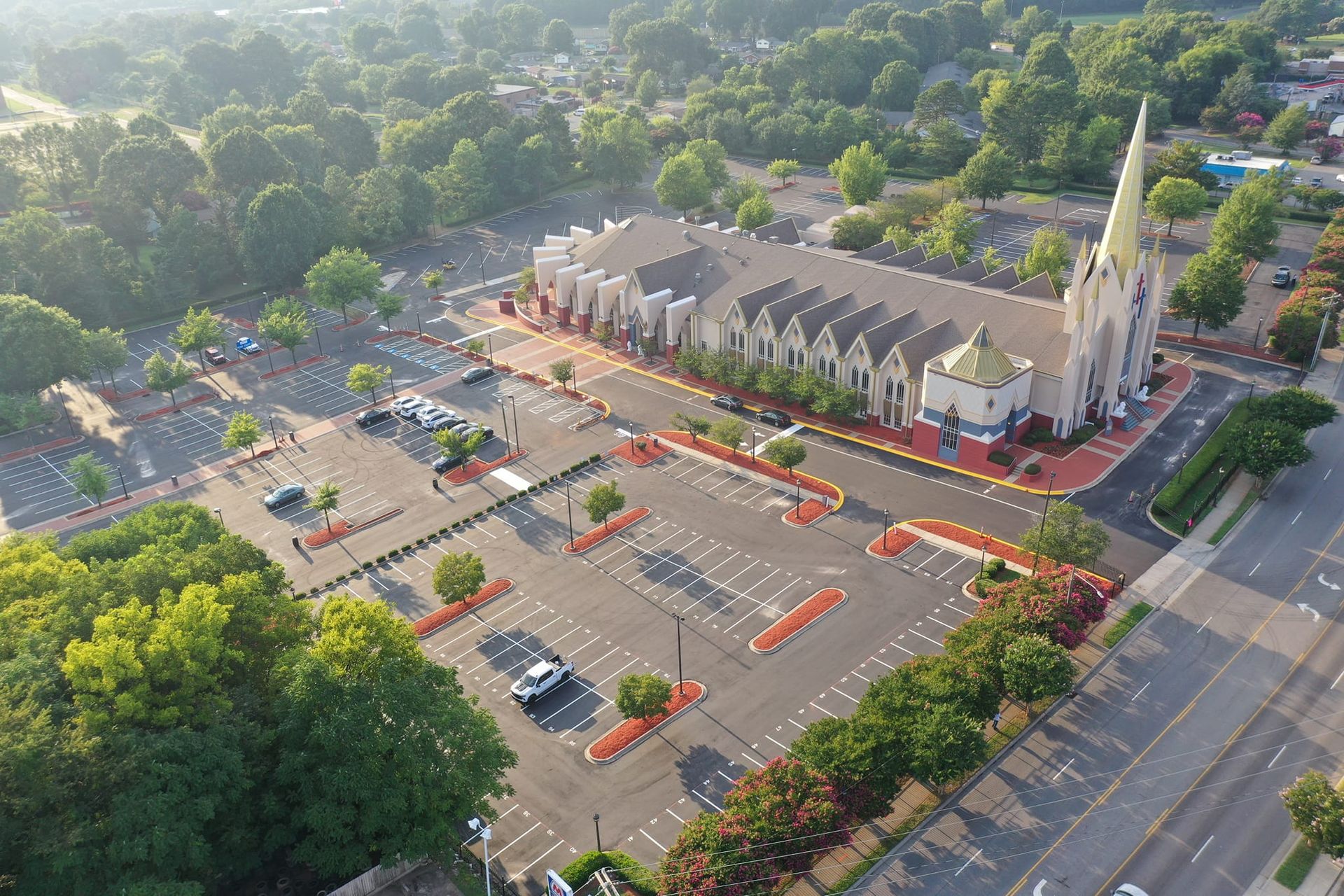 An aerial view of a church with a parking lot in front of it.