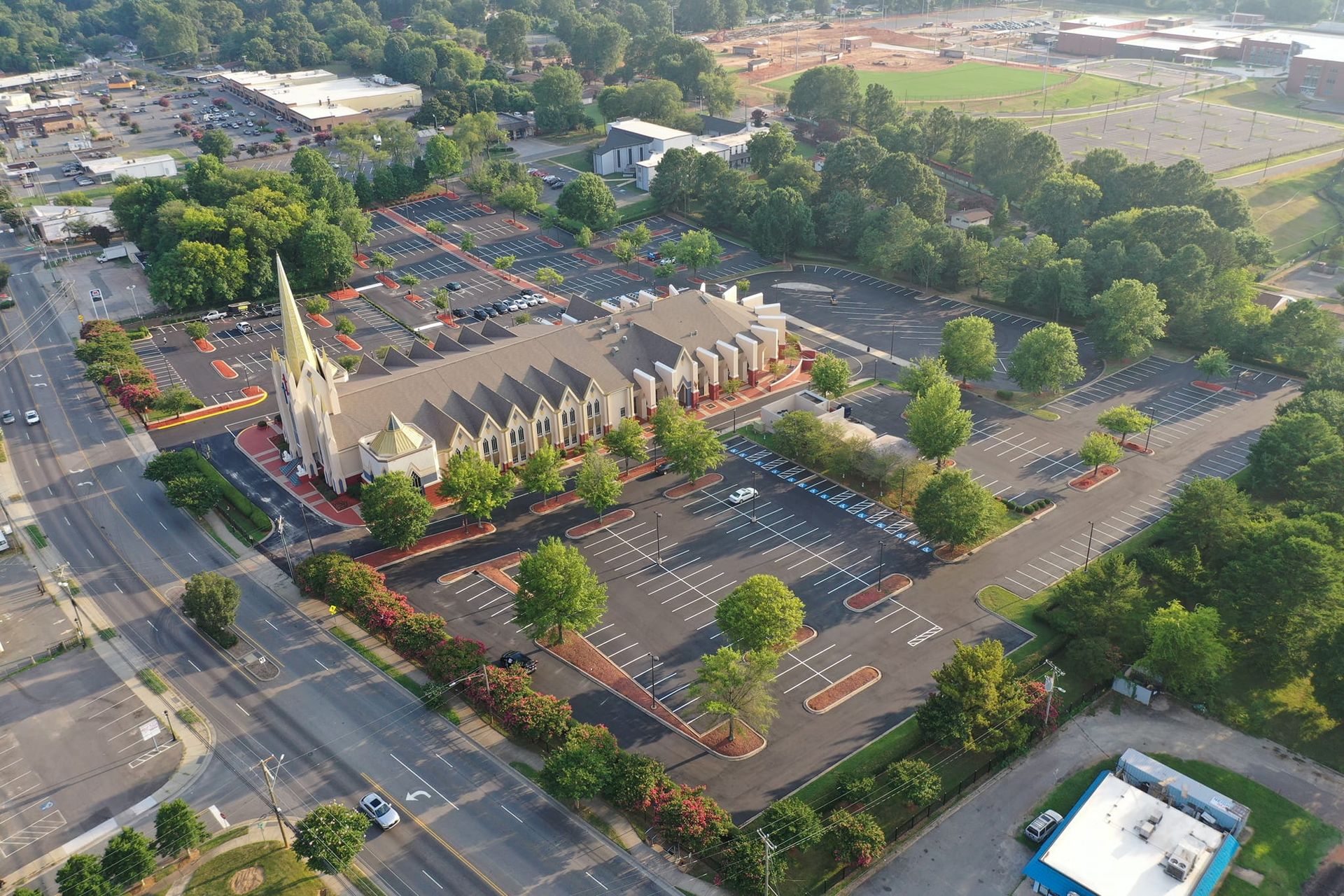 An aerial view of a church and parking lot in a city.