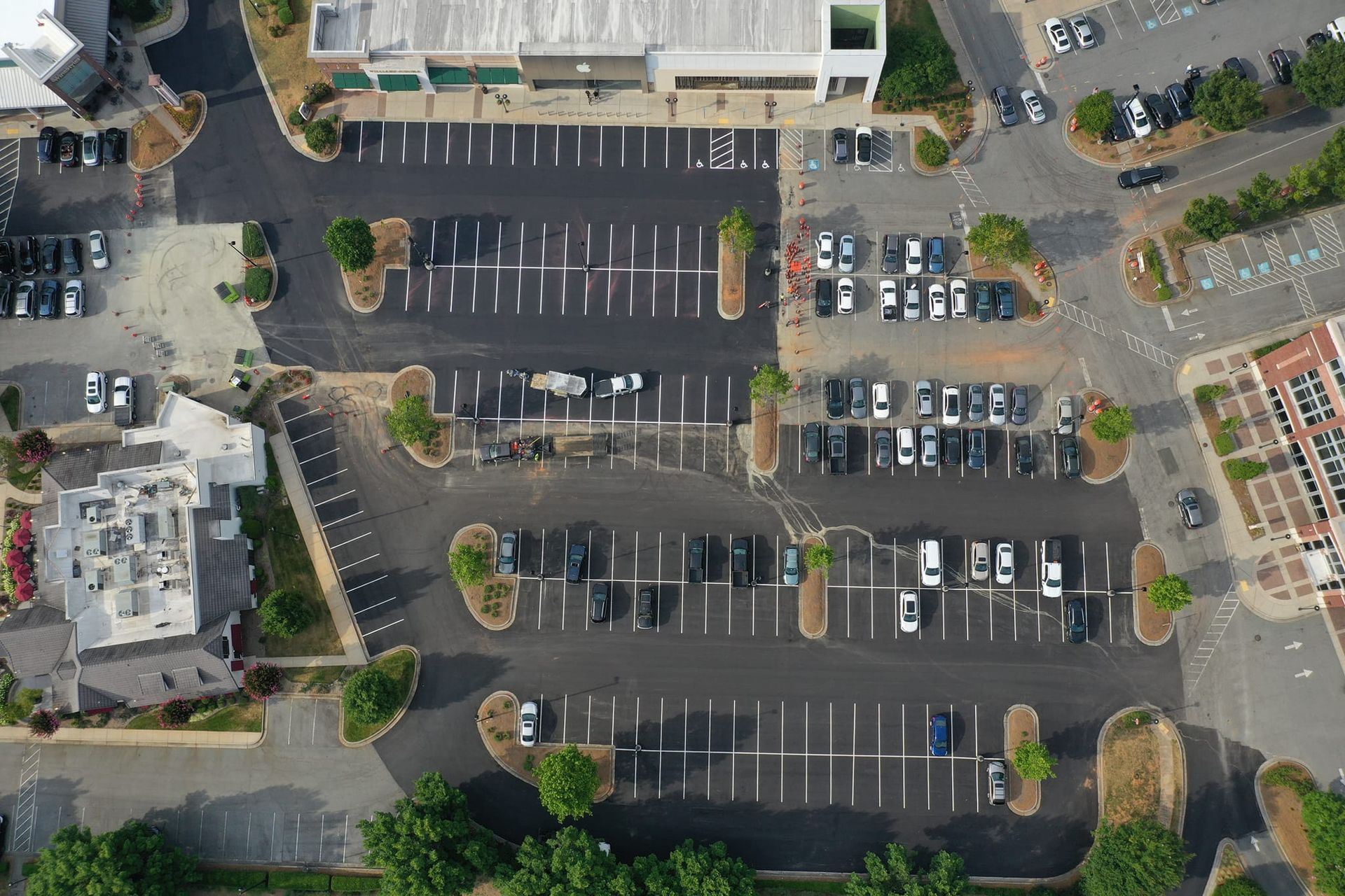 An aerial view of a parking lot with lots of cars parked in it