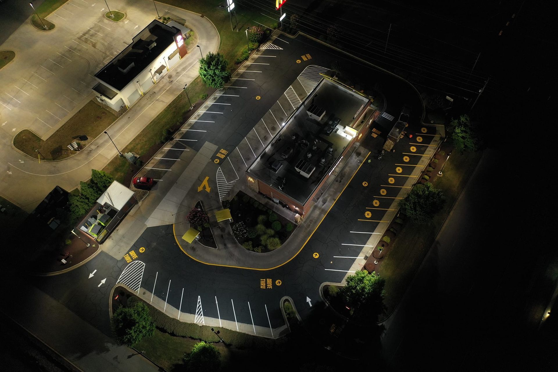 An aerial view of a Mcdonald 's  restaurant parking at night