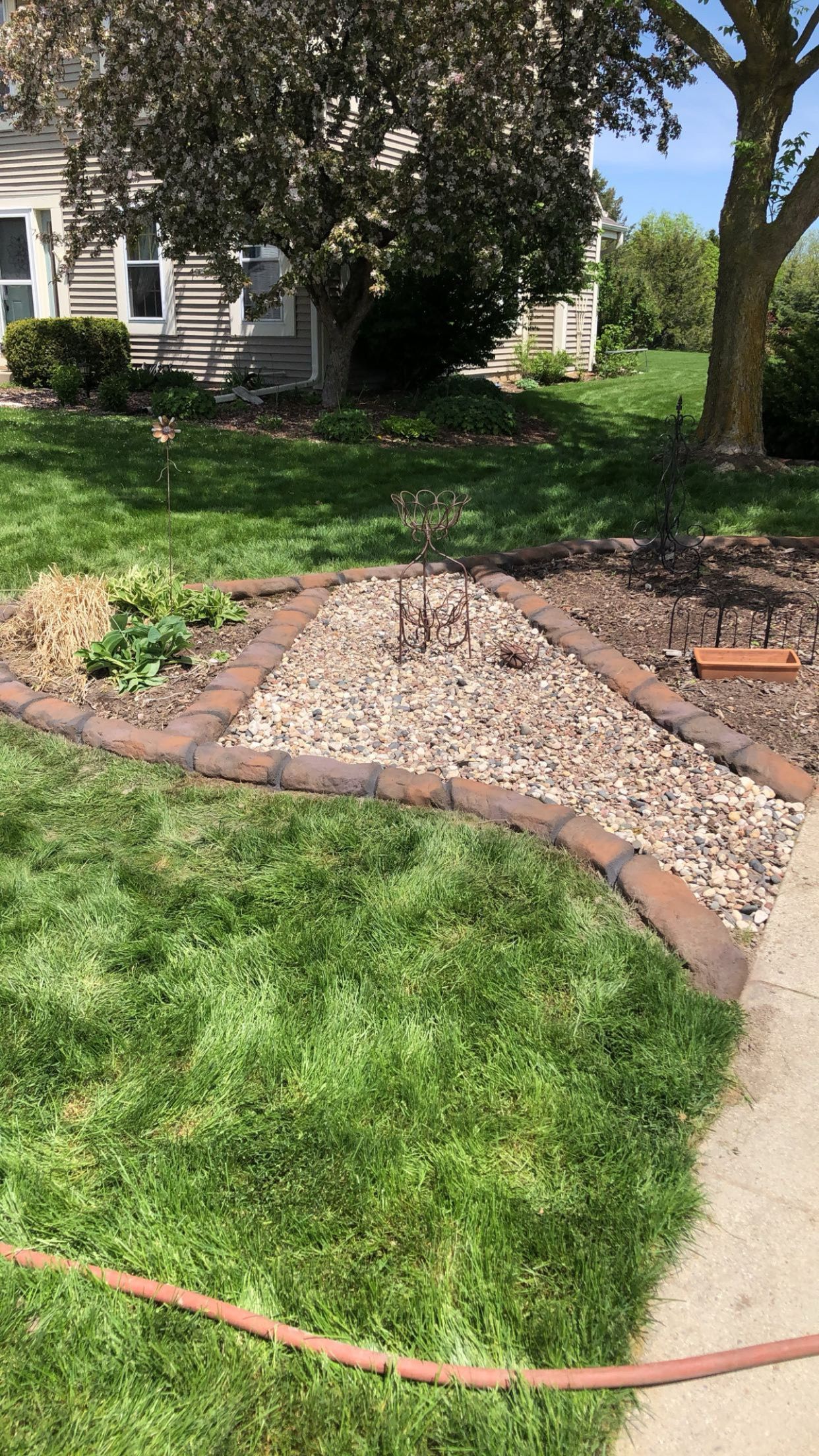 A hose is laying on the grass in front of a house.