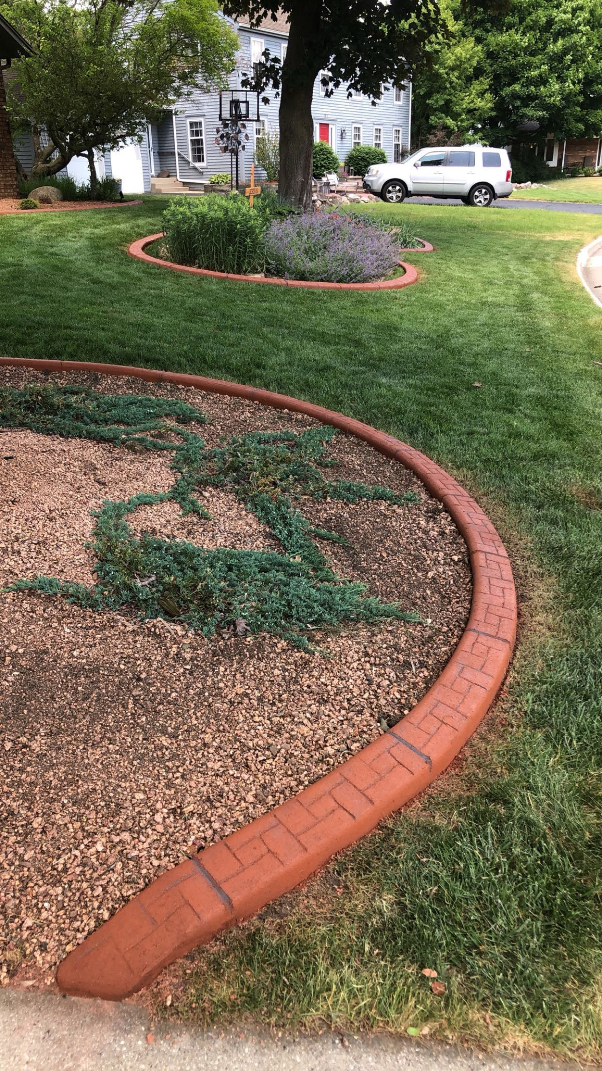 There is a brick curb in the middle of the yard.