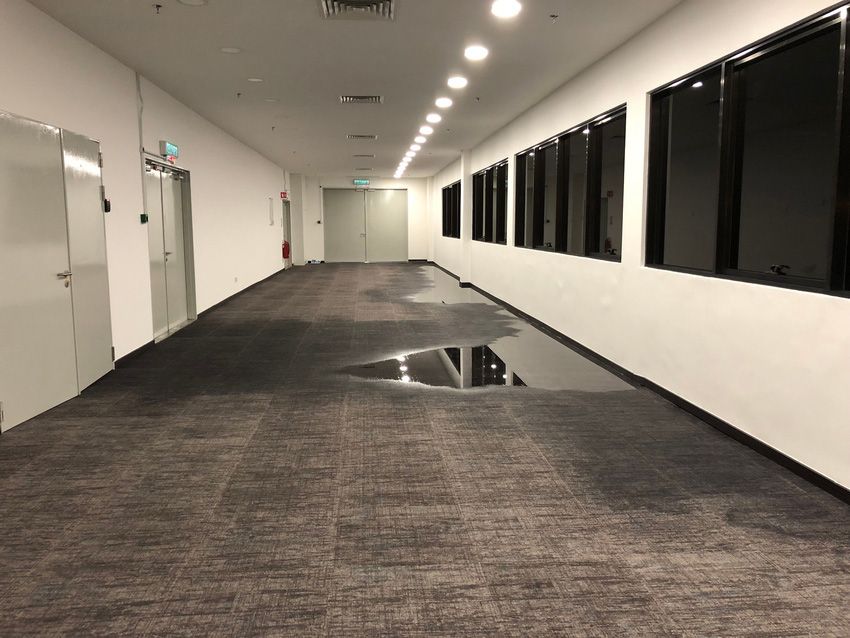 An empty hallway with a puddle of water on the floor
