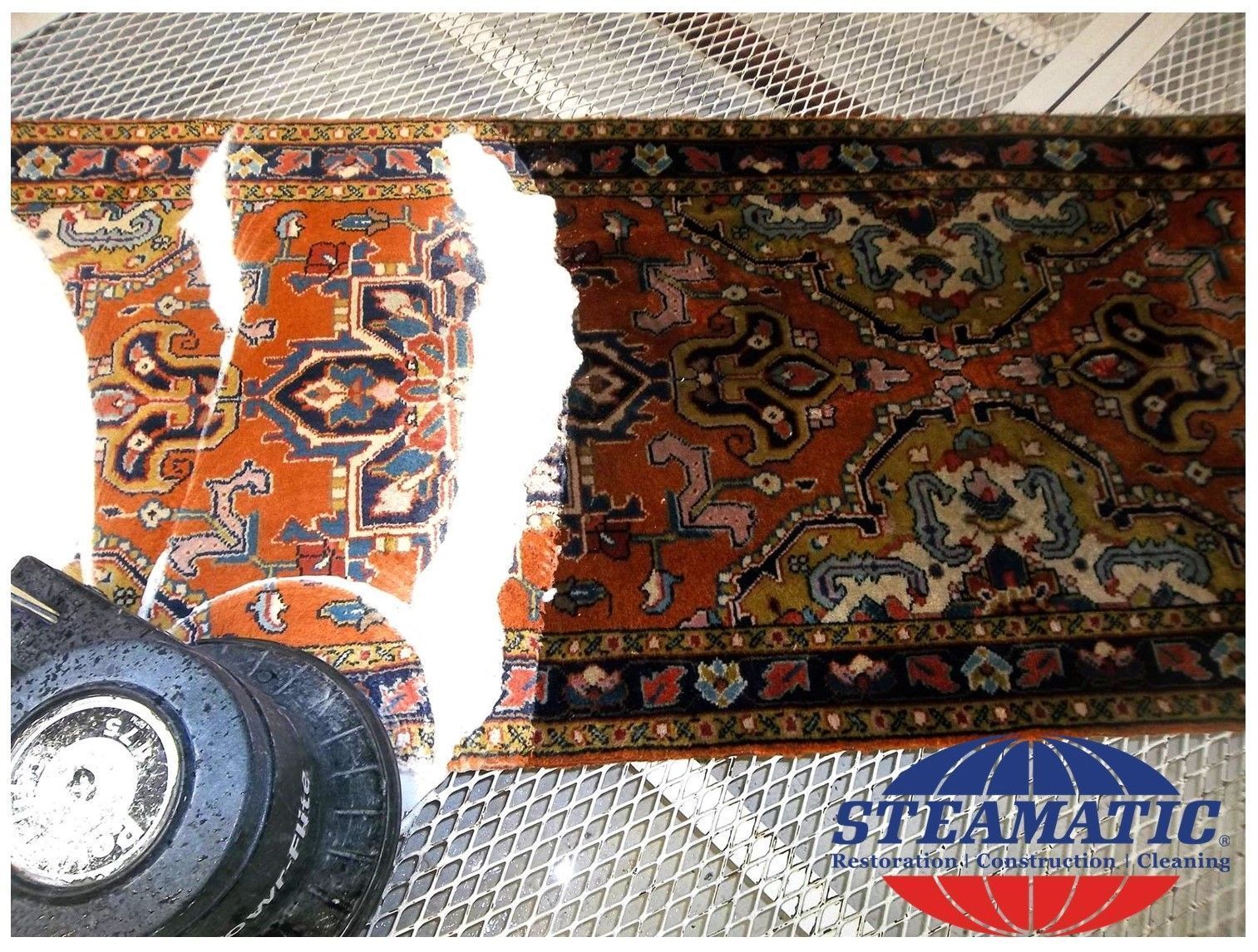 A picture of a rug with a tire next to it that says steammatic