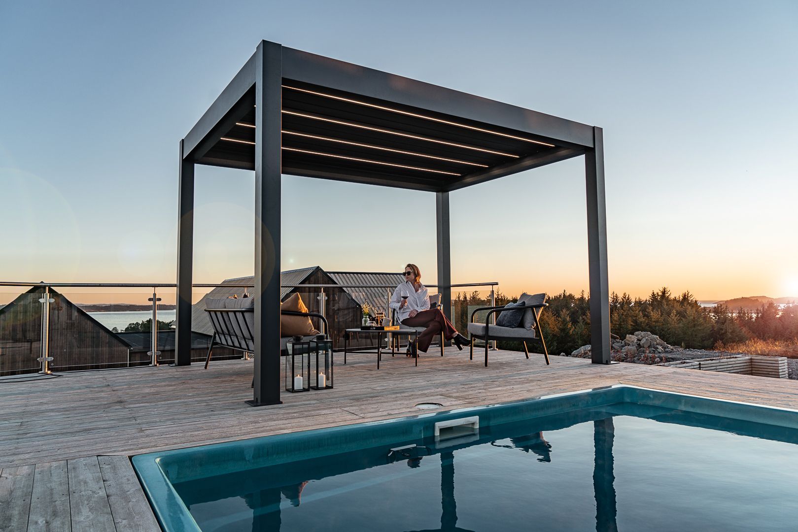 Rooftop pool beside a modern pergola lounge at sunset