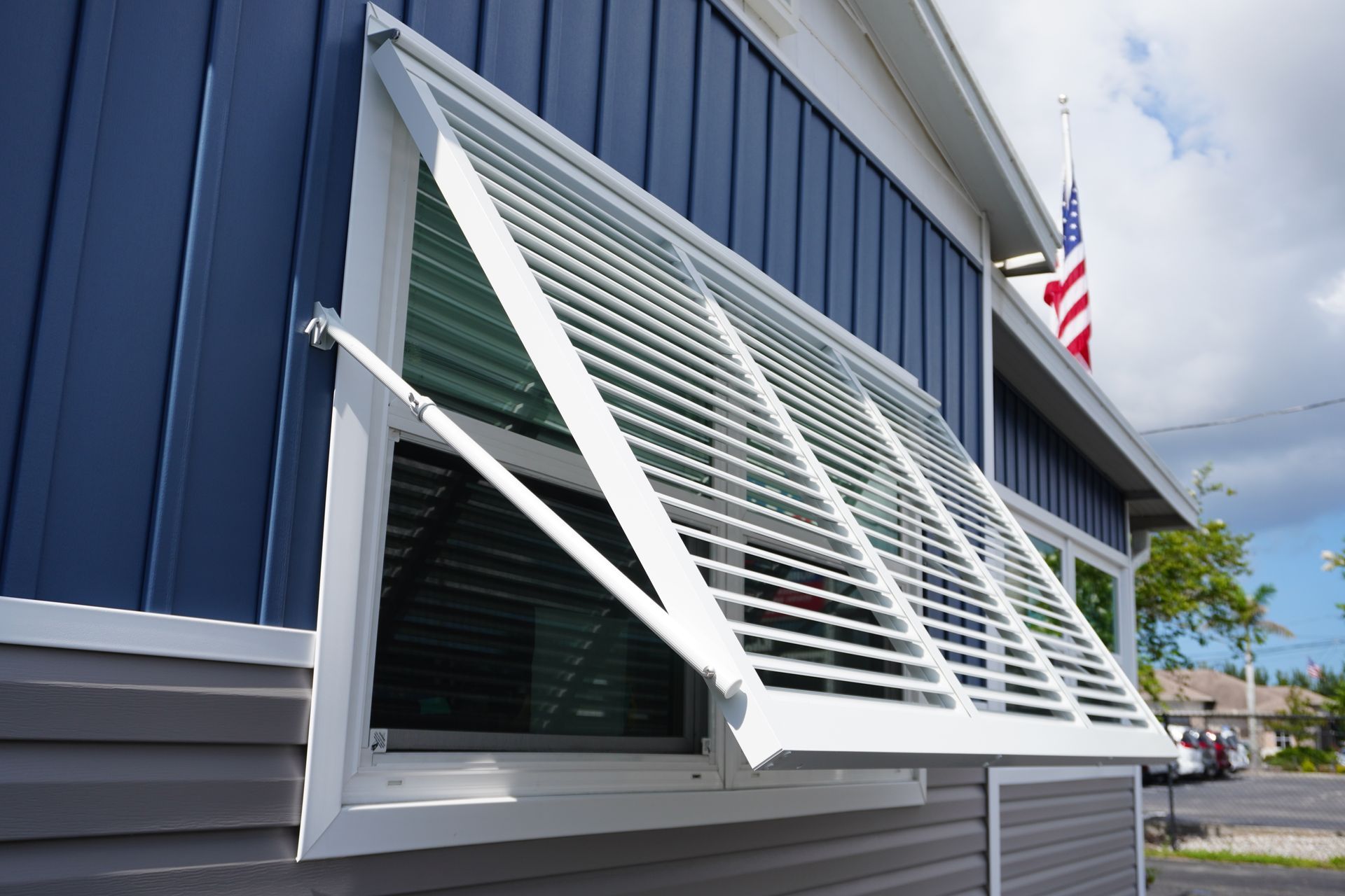 Open white window awning on a blue building exterior