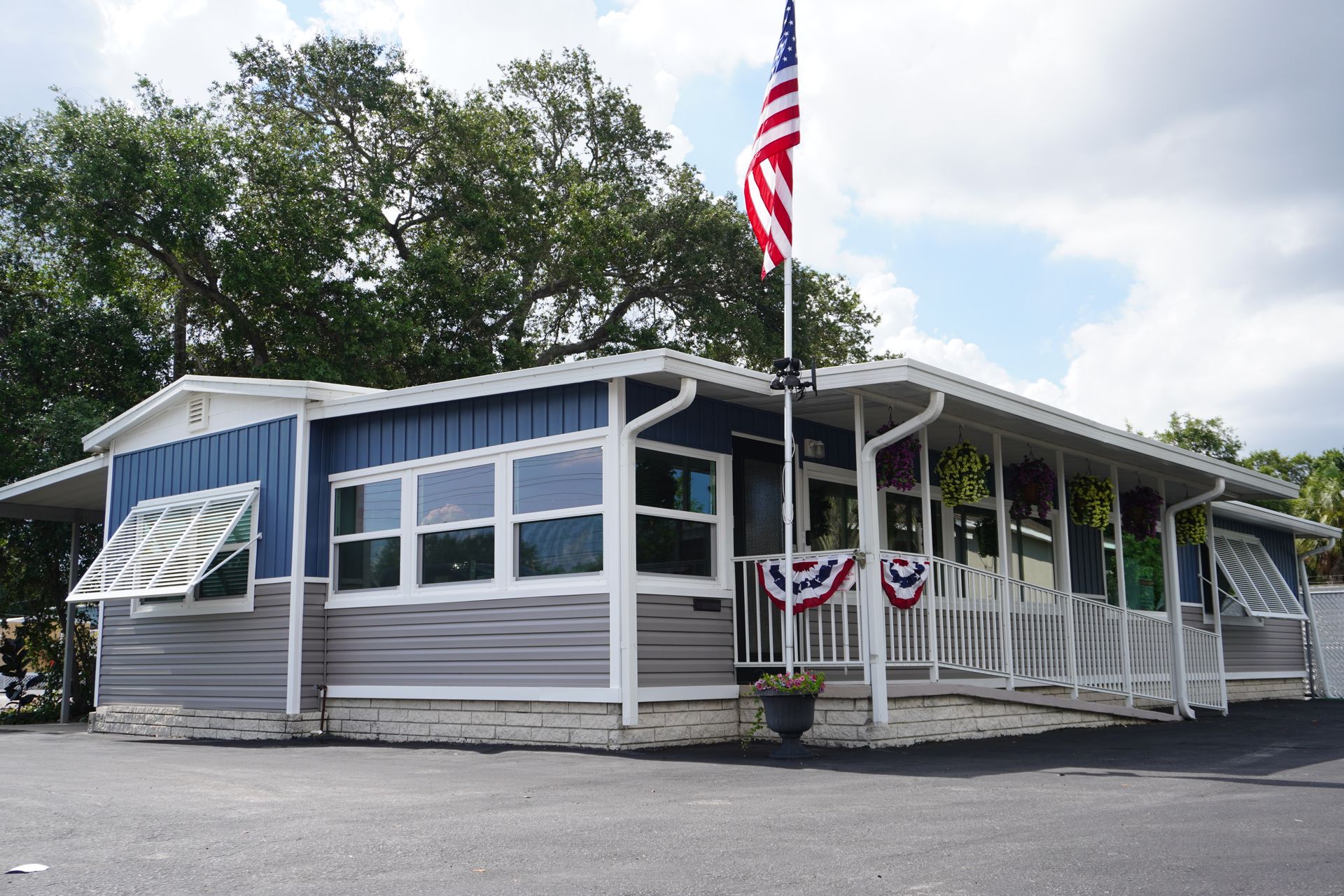 Small gray storefront with American flag and patriotic bunting on the porch