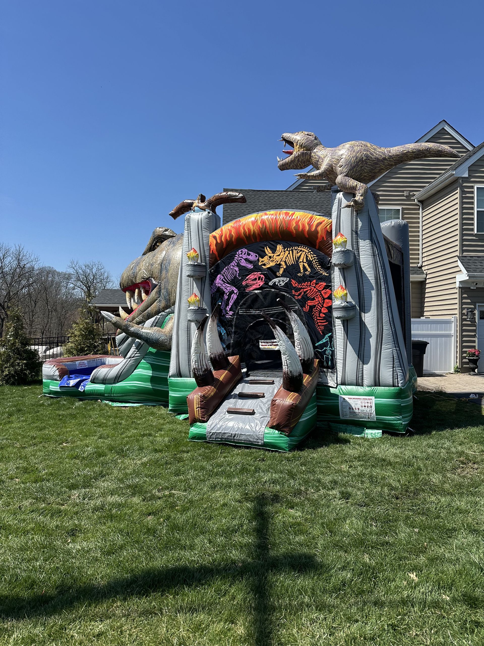 Colorful Halloween inflatable pirate ship in a front yard with a skeleton mast and orange archway