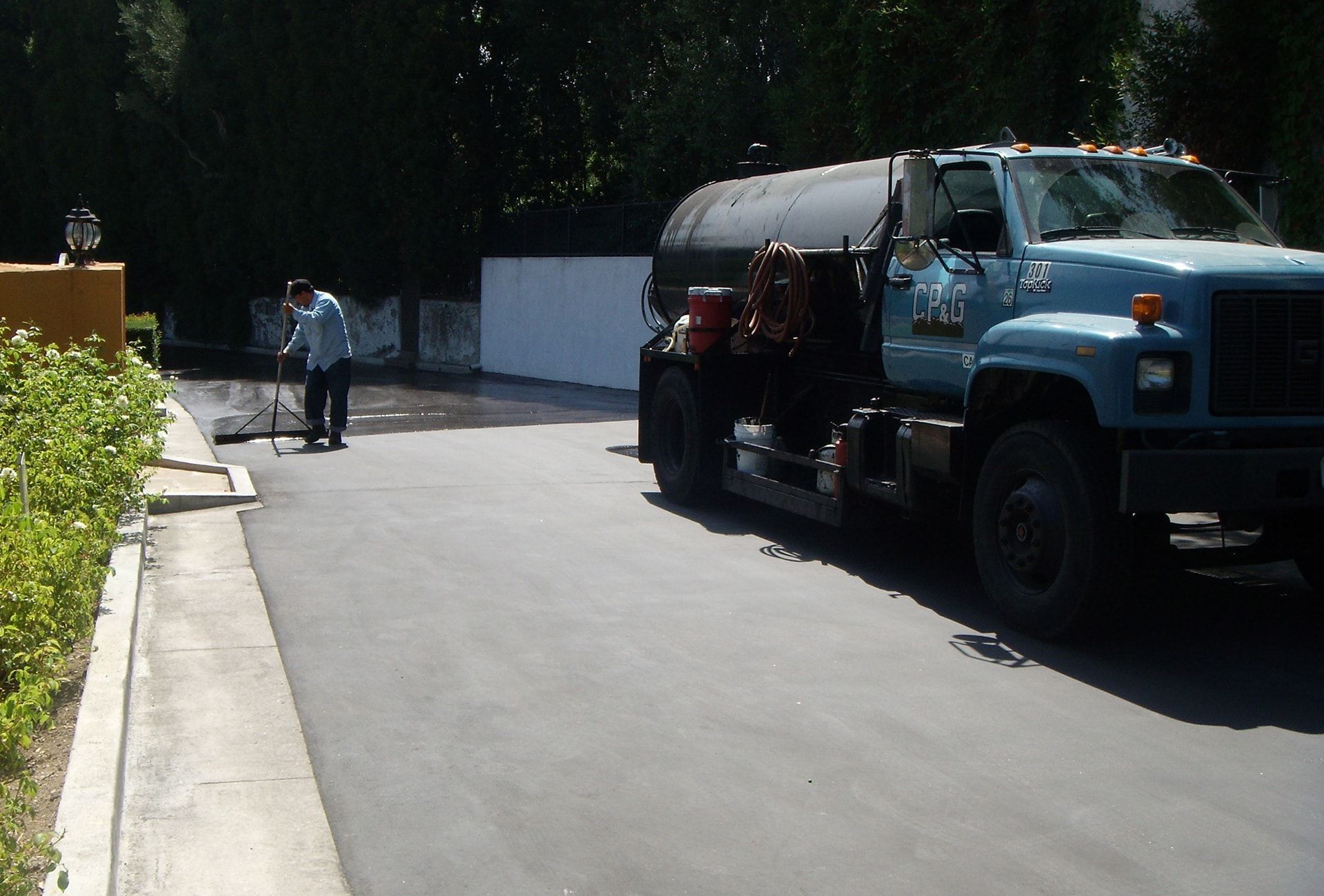 A blue truck is parked on the side of the road