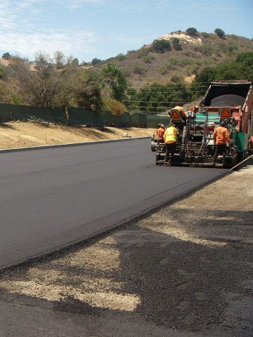 A group of construction workers are working on a road