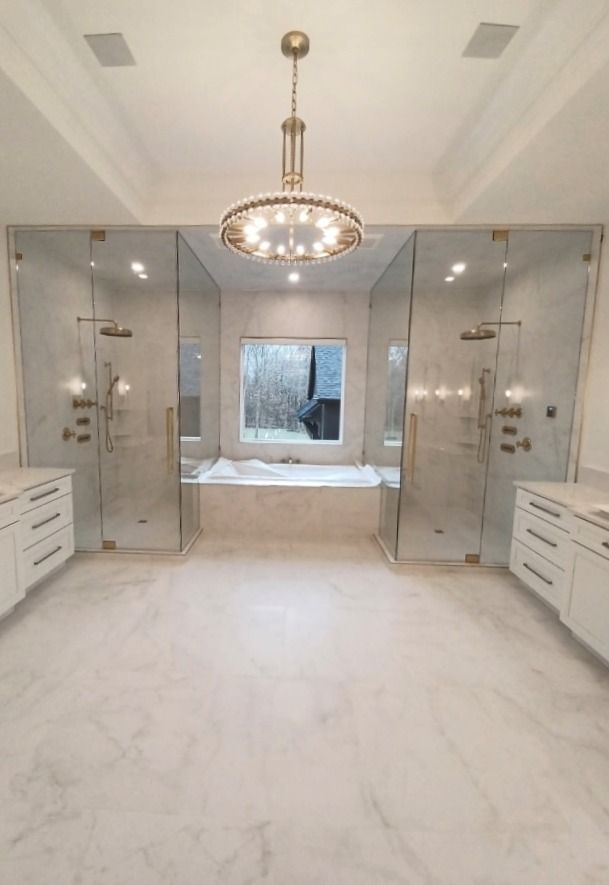 A bathroom with a tub, sinks, and a walk in shower.