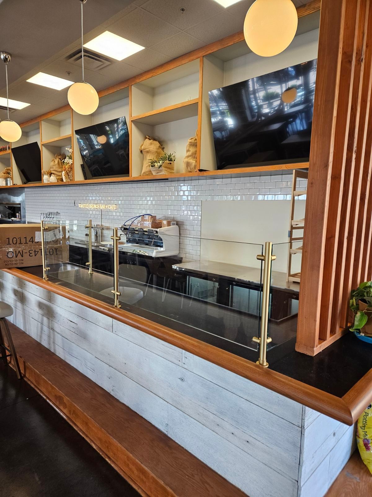 A restaurant with a long counter and a glass divider.
