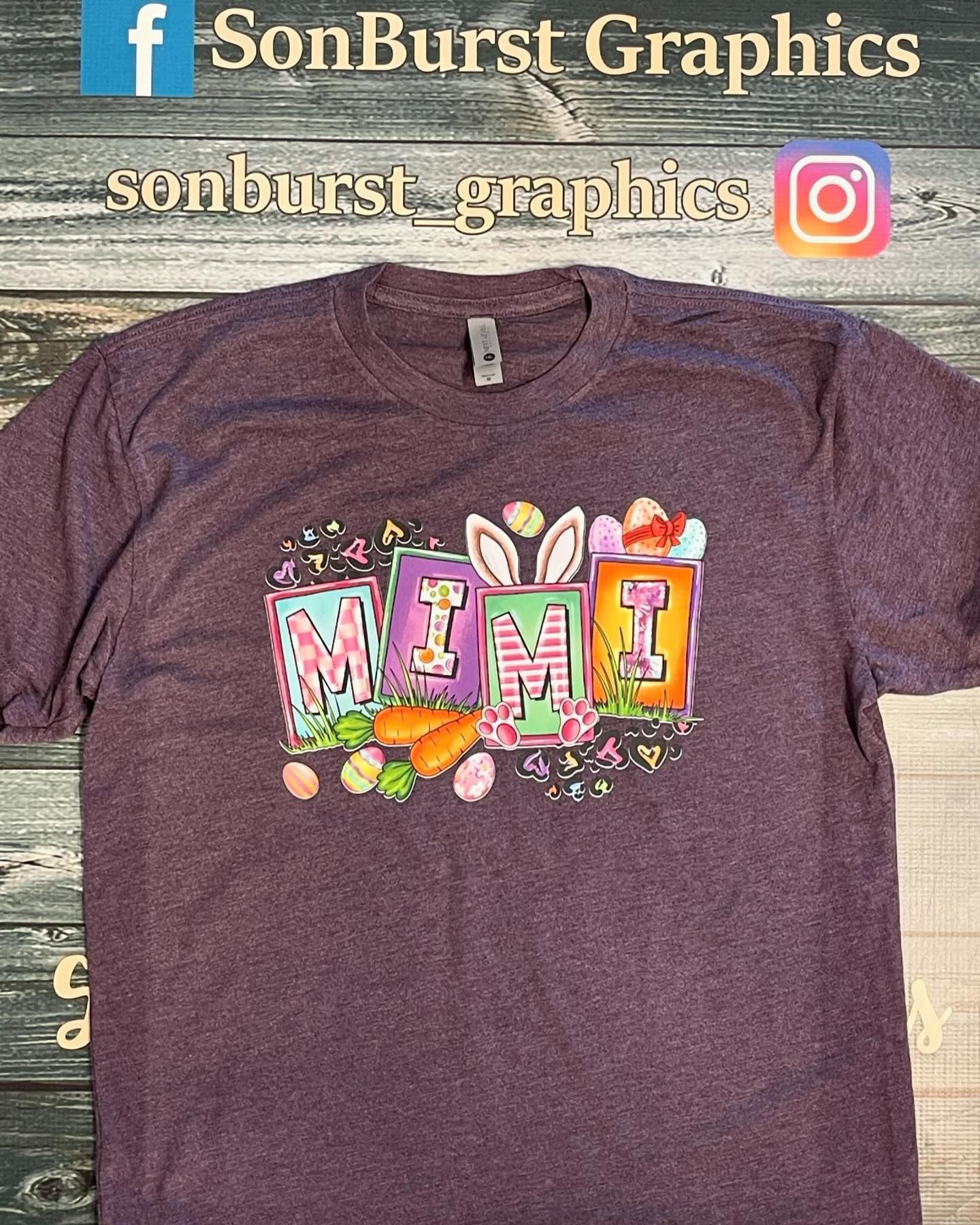 A purple t-shirt with the word mom on it is sitting on a wooden table.