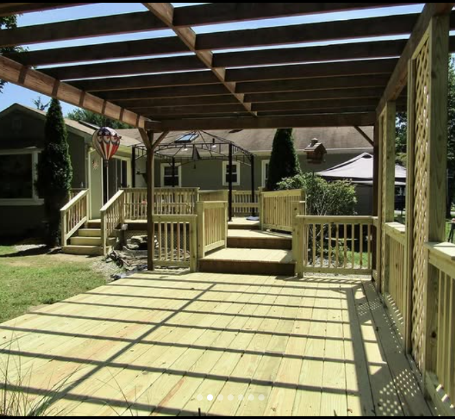 Wooden deck with pergola overhead, steps, and railings