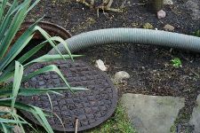 A manhole cover with a hose attached to it.