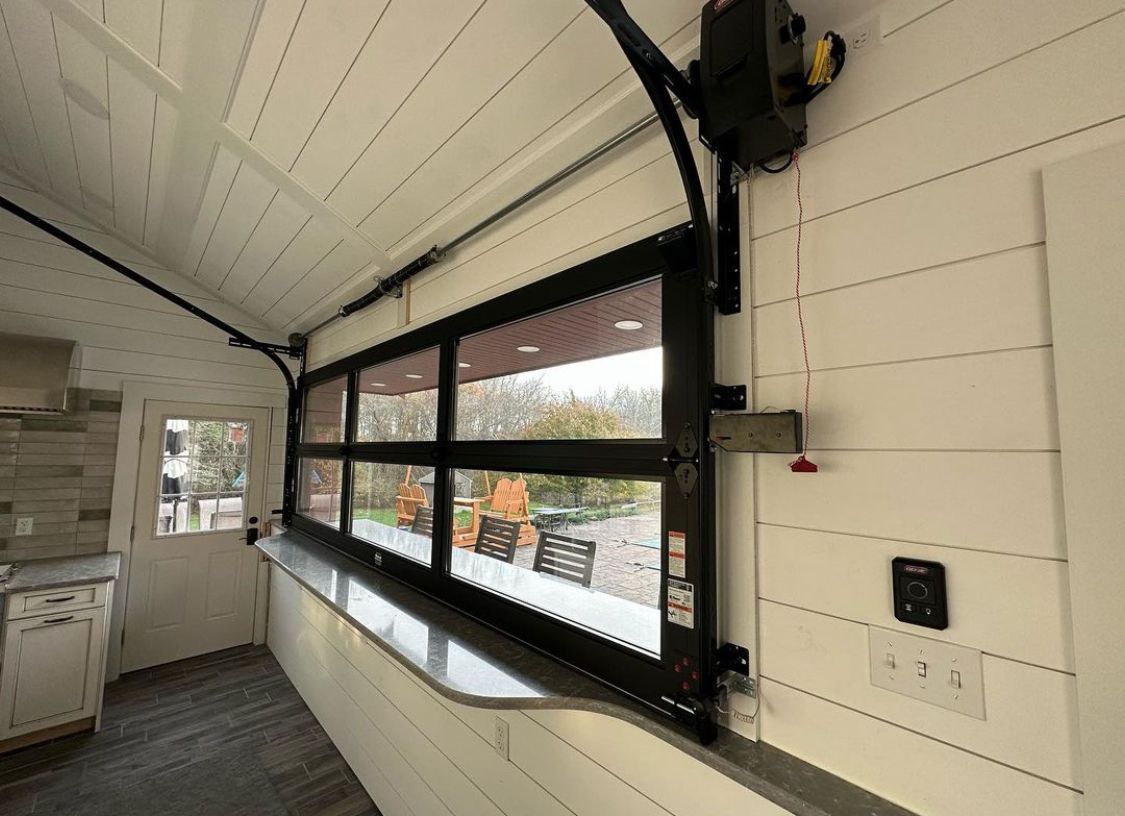 Interior view of a covered service window with black-framed awning and white paneled walls