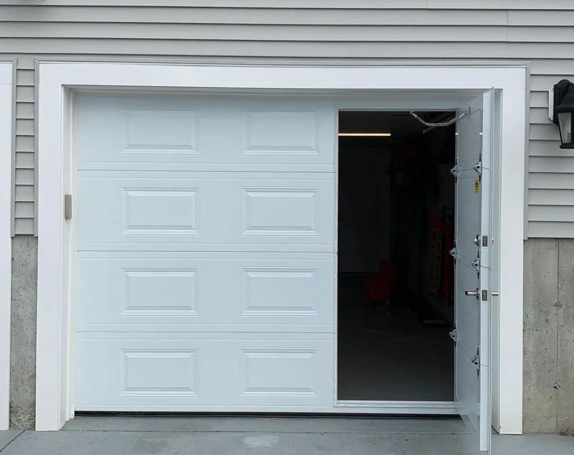 Partially open white garage door on a house exterior