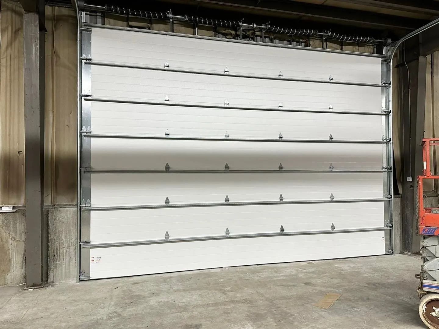 Closed white industrial roll-up garage door in a warehouse loading bay