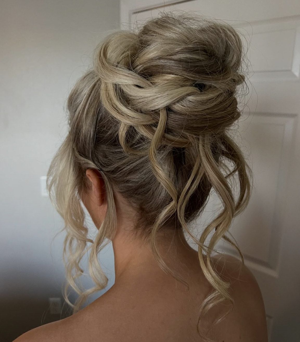 A woman is wearing her hair in a messy bun.