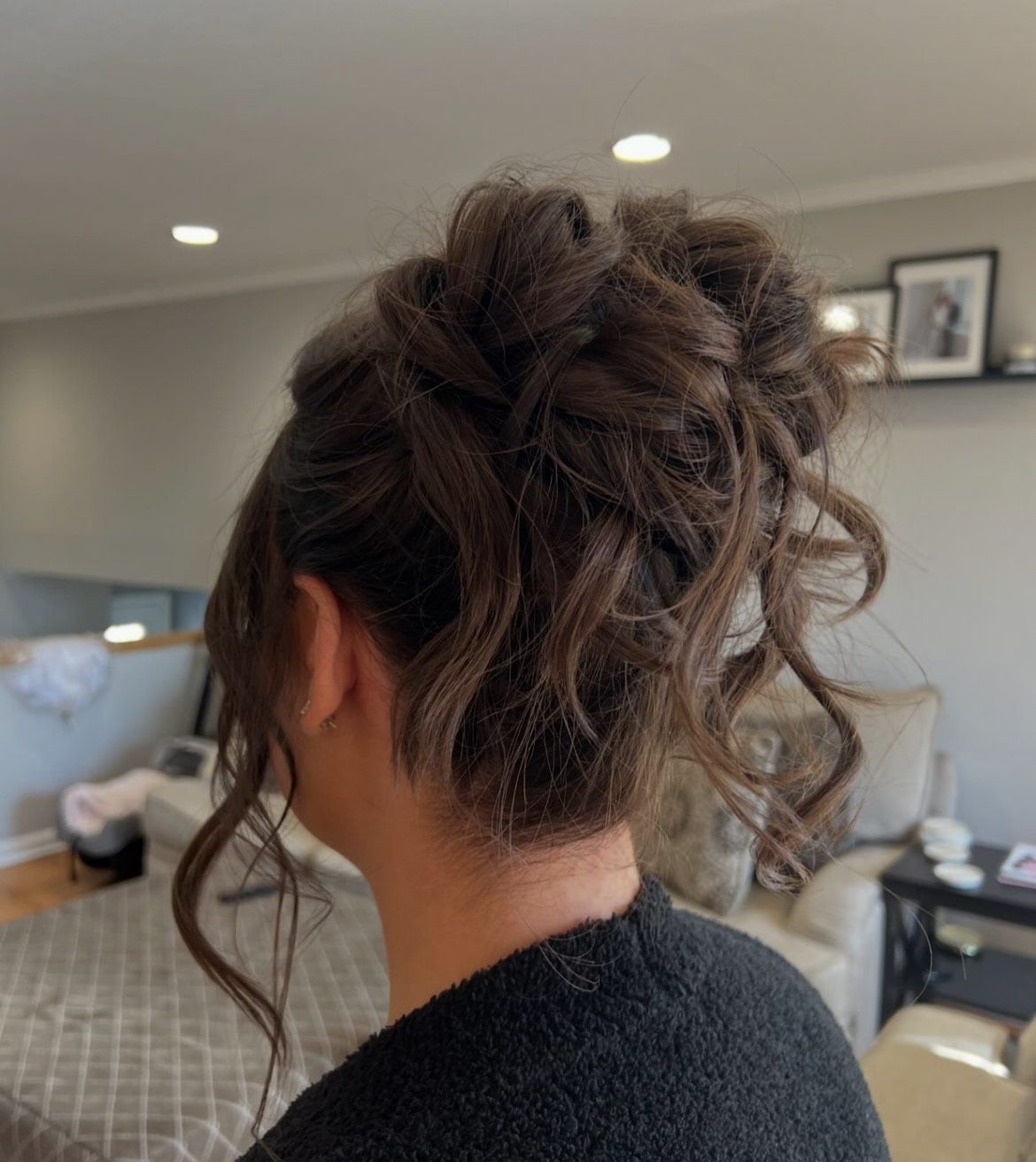 A woman is wearing her hair in a messy bun.