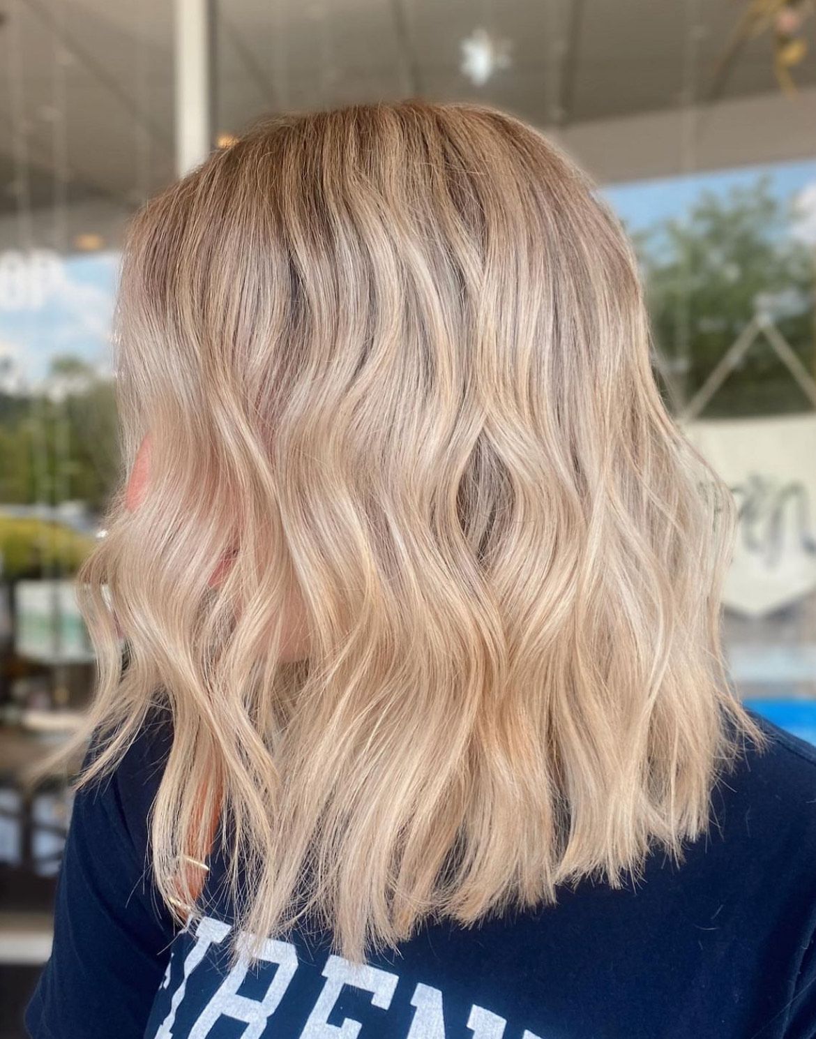 A woman with blonde hair is wearing a blue shirt.